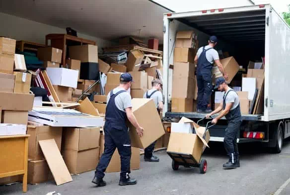 Équipe professionnelle de débarras en action : tri, chargement et organisation d'un vidage maison