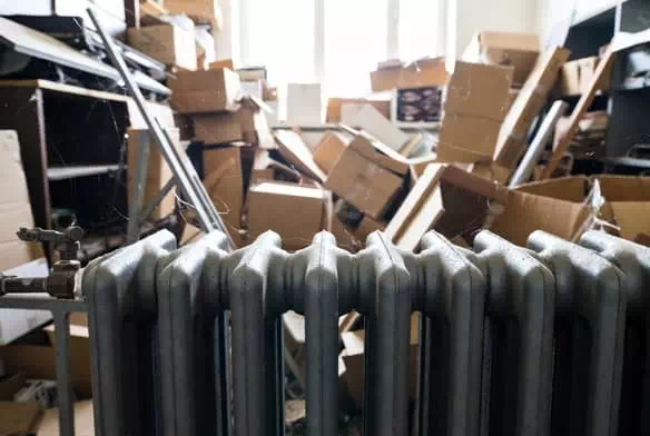 Pièce encombrée avec radiateur en fonte trouvé lors d'un débarras maison